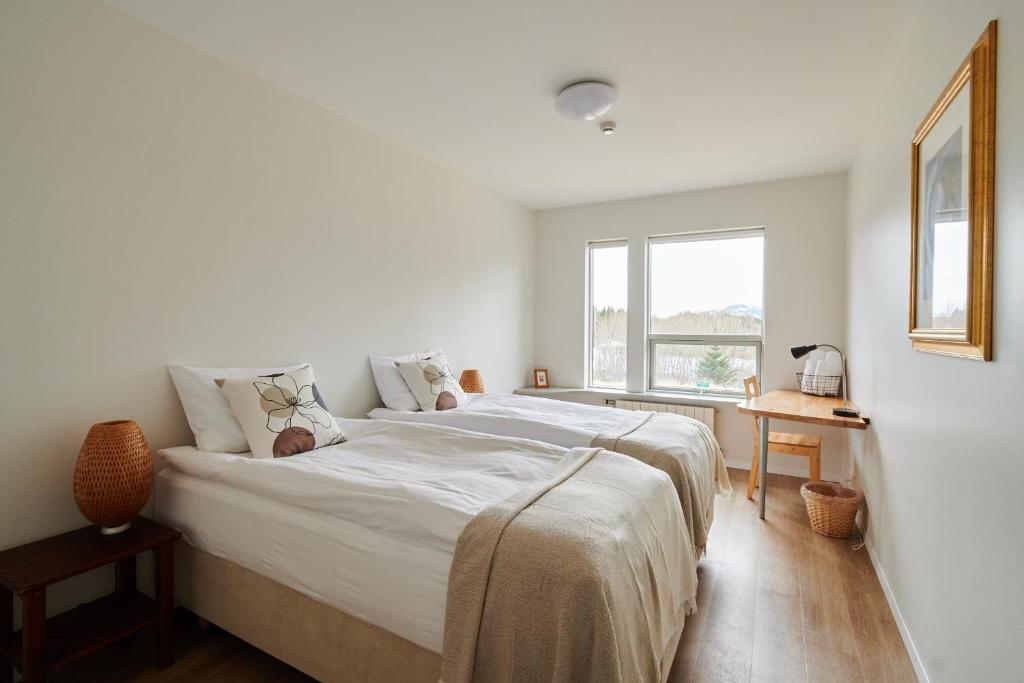 Sólheimar索海姆生态村旅馆的白色的卧室设有一张大床和一个窗户