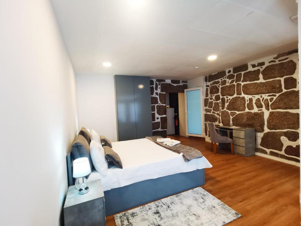 吉马良斯Alojamento Local F&B的一间设有床铺和石墙的房间