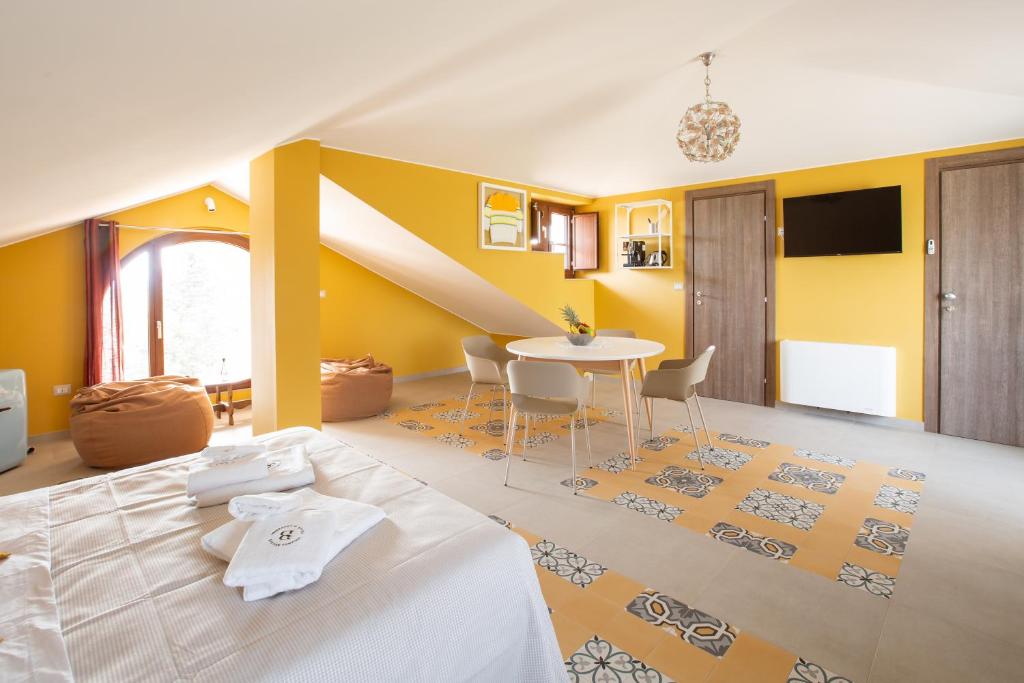 DelicetoLocanda Ballarò Relais di Campagna的一间卧室设有一张床铺、一张桌子和黄色的墙壁