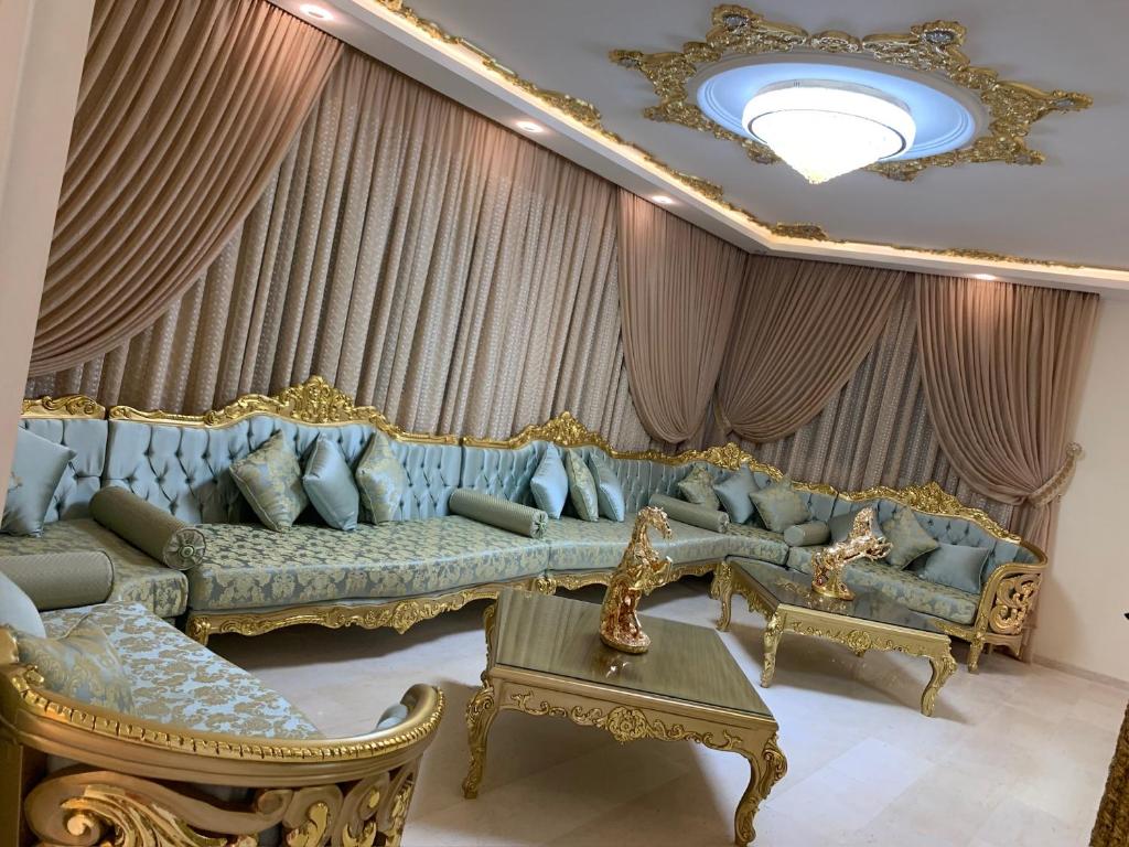 马赫迪耶Maison Fathallah的客厅配有蓝色沙发和金饰