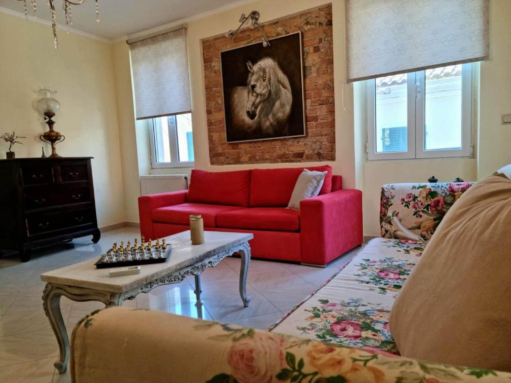 AnemómylosVilla Maxim in Corfu Town的客厅配有红色沙发和马术画