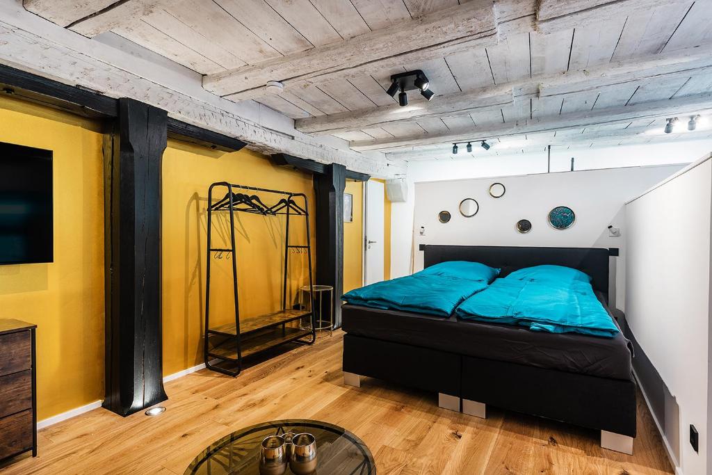康斯坦茨Goldliebe的卧室配有一张床铺,位于一个黄色墙壁的房间