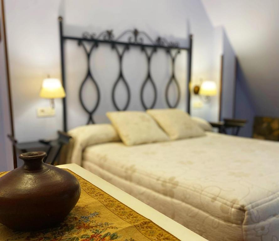 乌迪亚莱斯堡La Llosa de Sámano的一间卧室,配有一张床和一张桌子上的花瓶