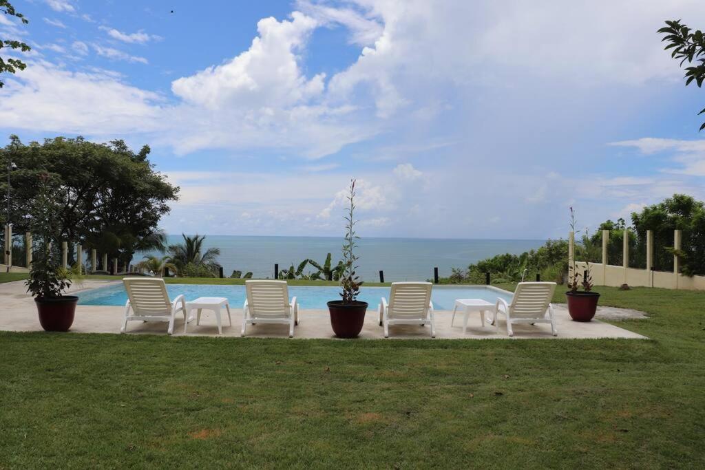 圣卡洛斯Secluded Ocean Front Overlooking the Marina的一组坐在泳池旁的白色椅子