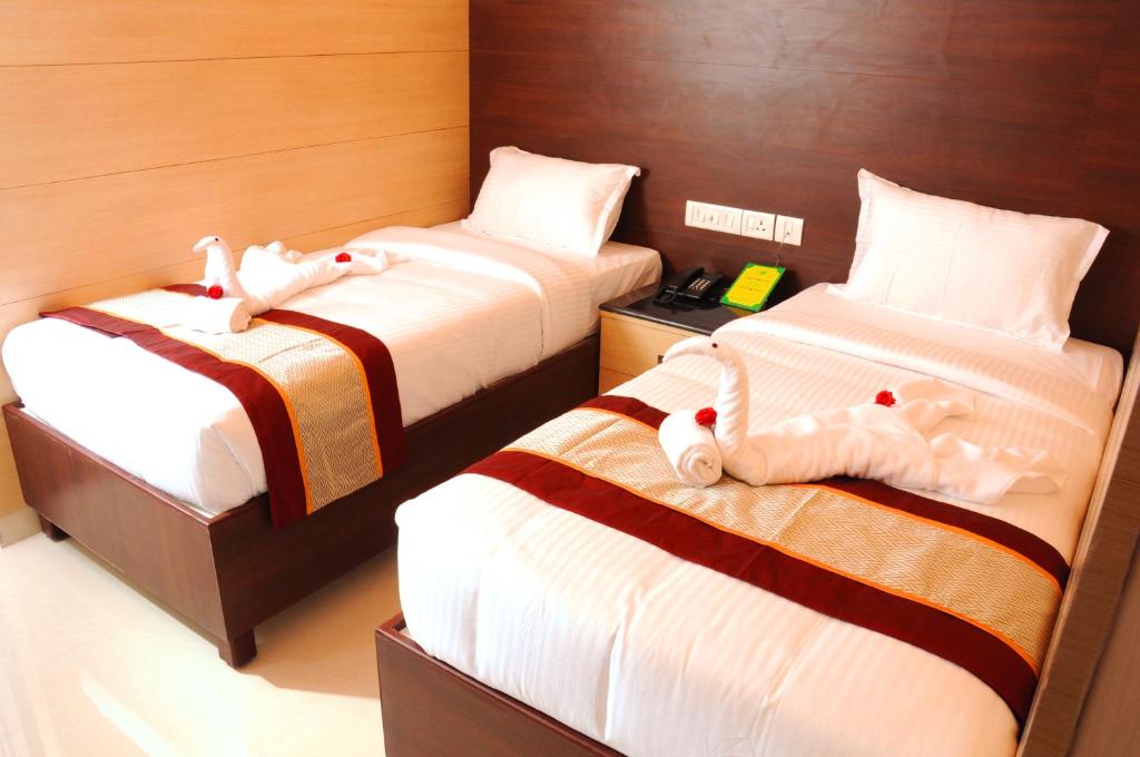 钦奈Sai Budget Hotel Chennai Airport的一间设有两张床的房间,里面装满了动物