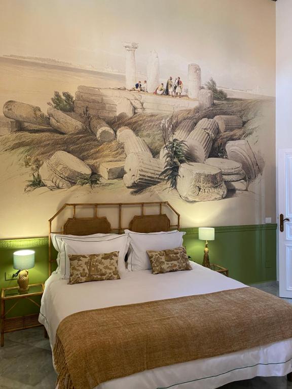 提尔Dar Alice的卧室配有一张大床,墙上挂有绘画作品