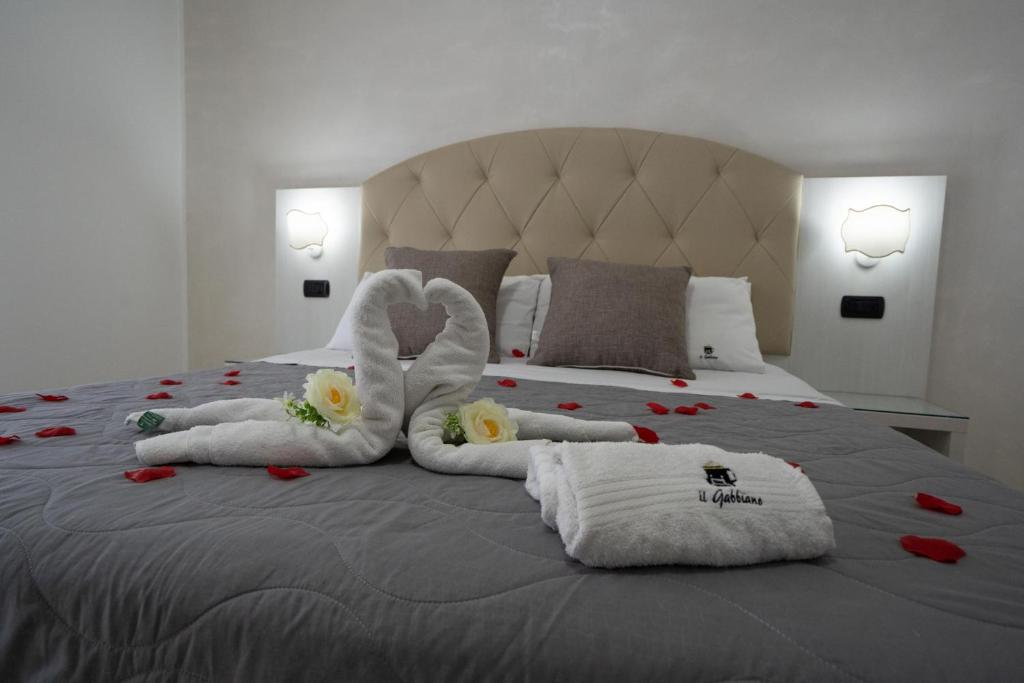 切萨雷奥港B&B Il Gabbiano的一间卧室配有带毛巾和鲜花的床