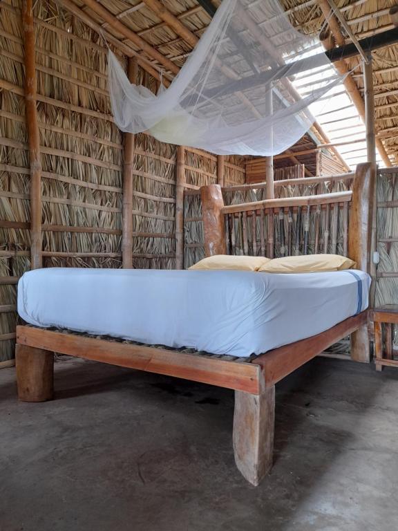 BalgueEl Bamboo Cabins的一张位于带蚊帐的房间内的床铺