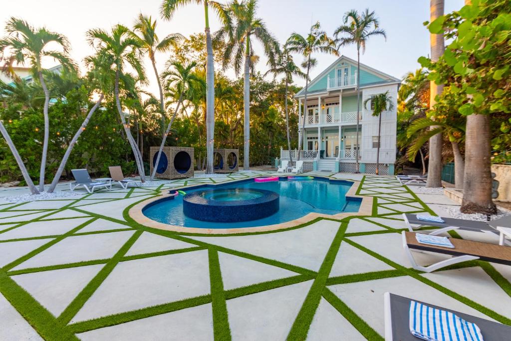 伊斯拉莫拉达Beachfront Villa at Islamorada BY THE GLAMHOMES的棕榈树和房屋的游泳池