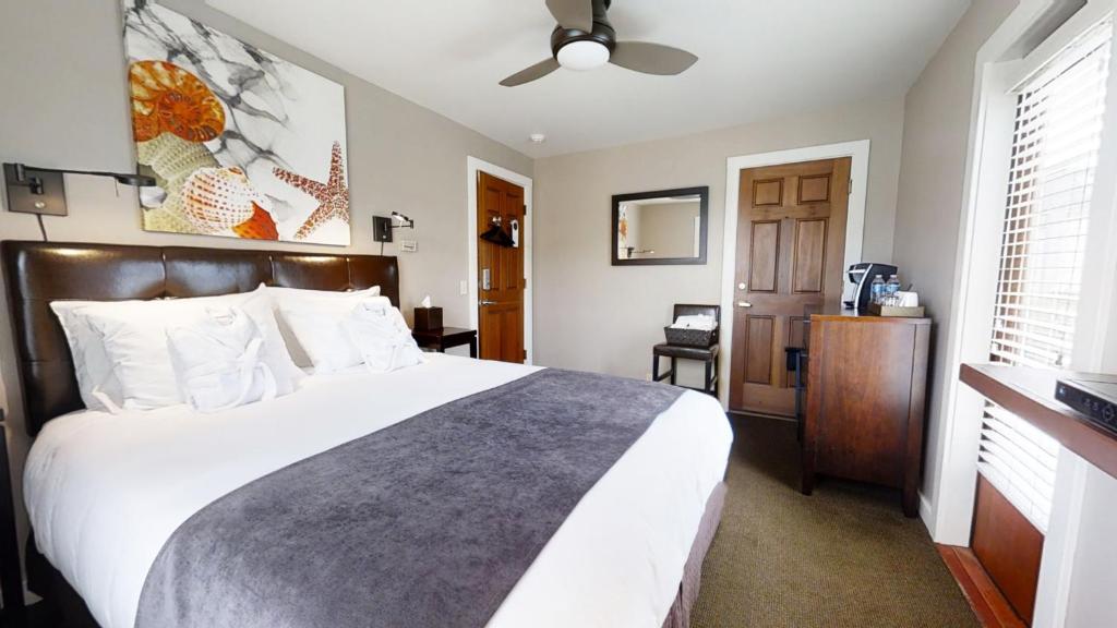 星期五港鸟岩酒店的卧室设有一张白色大床和一扇窗户。