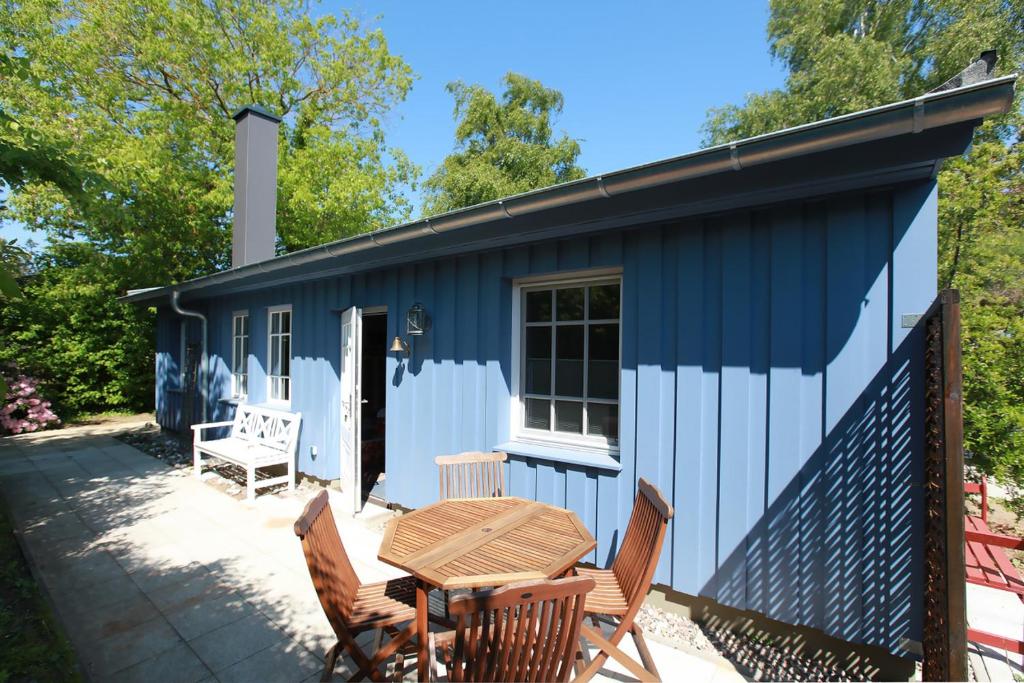 欧巴德伍斯图Strandnest的蓝色和白色的小屋,配有桌椅
