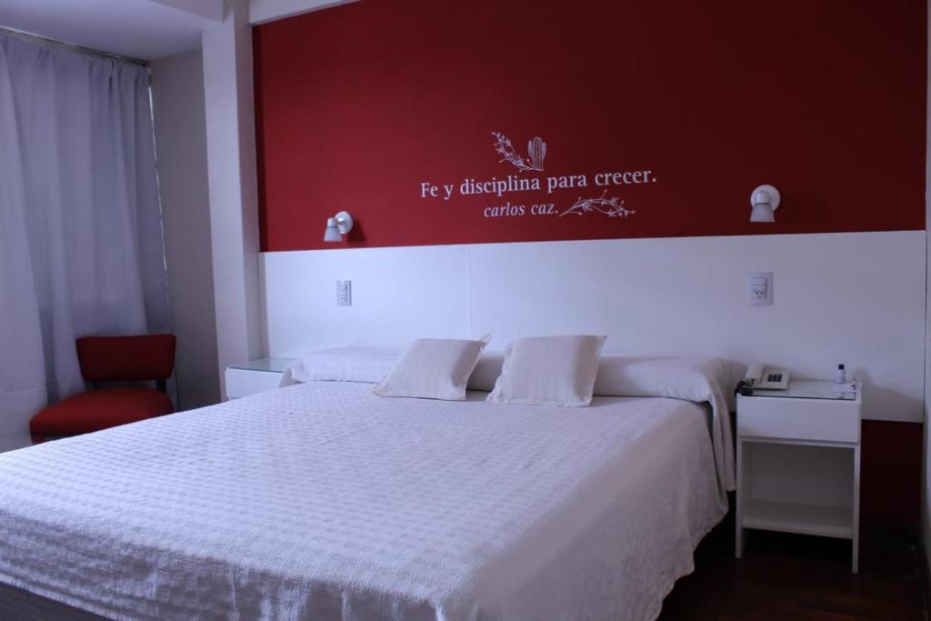 雷孔基斯塔Hotel Ychoalay Caz的卧室配有白色的床和红色的墙壁