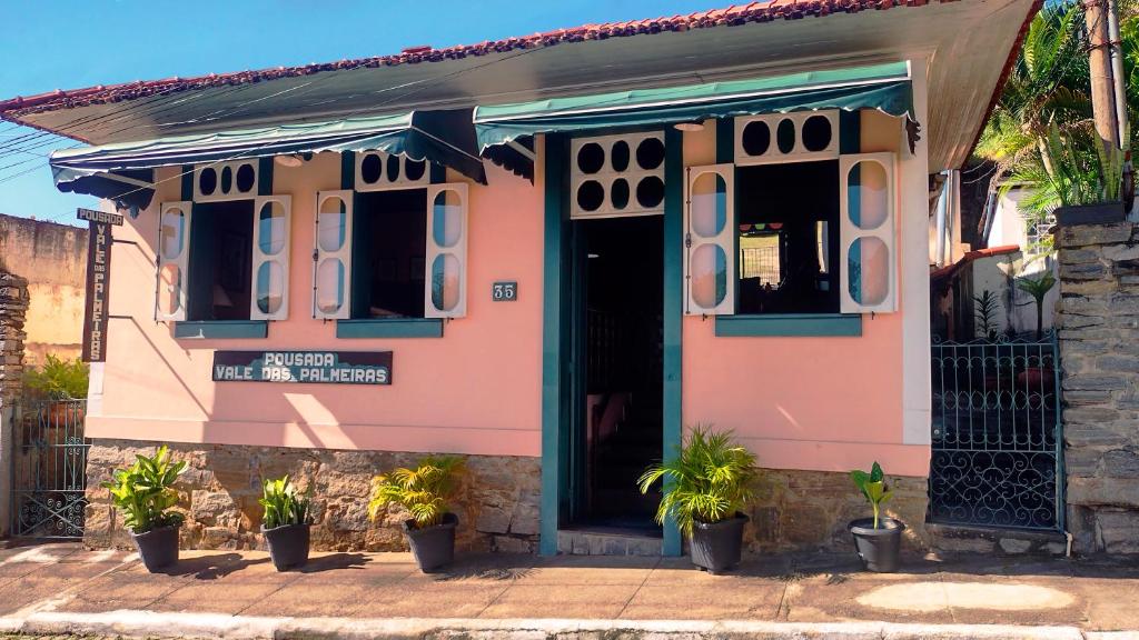 瓦索拉斯帕尔梅拉斯河谷酒店的前面有盆栽植物的粉红色房子