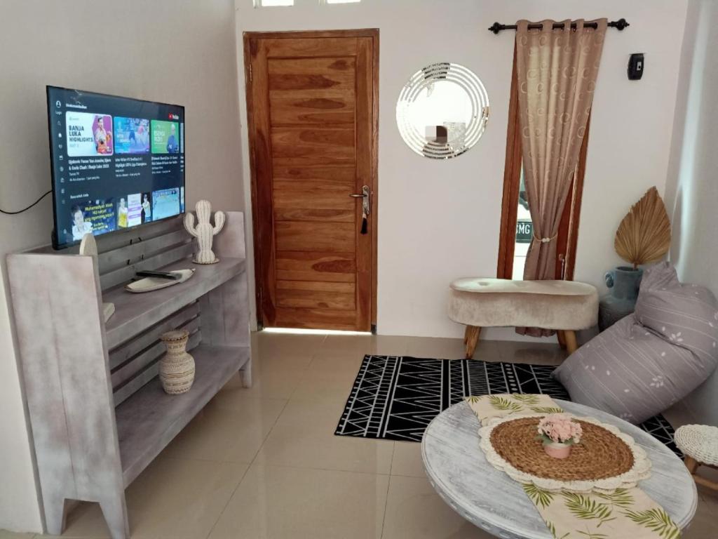 日惹rindoe jogja holiday home的客厅配有电视、沙发和桌子