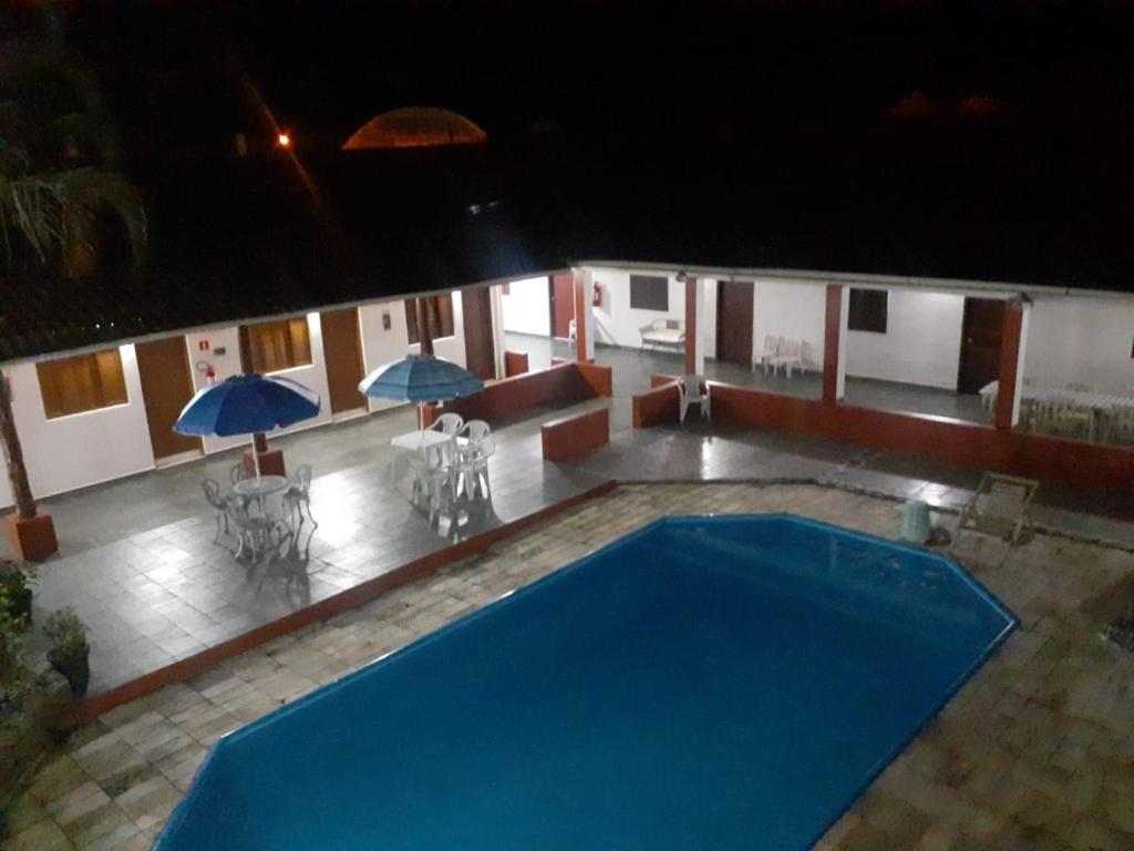 卡纳内亚Pousada Por do Sol的一座带遮阳伞的大型蓝色游泳池