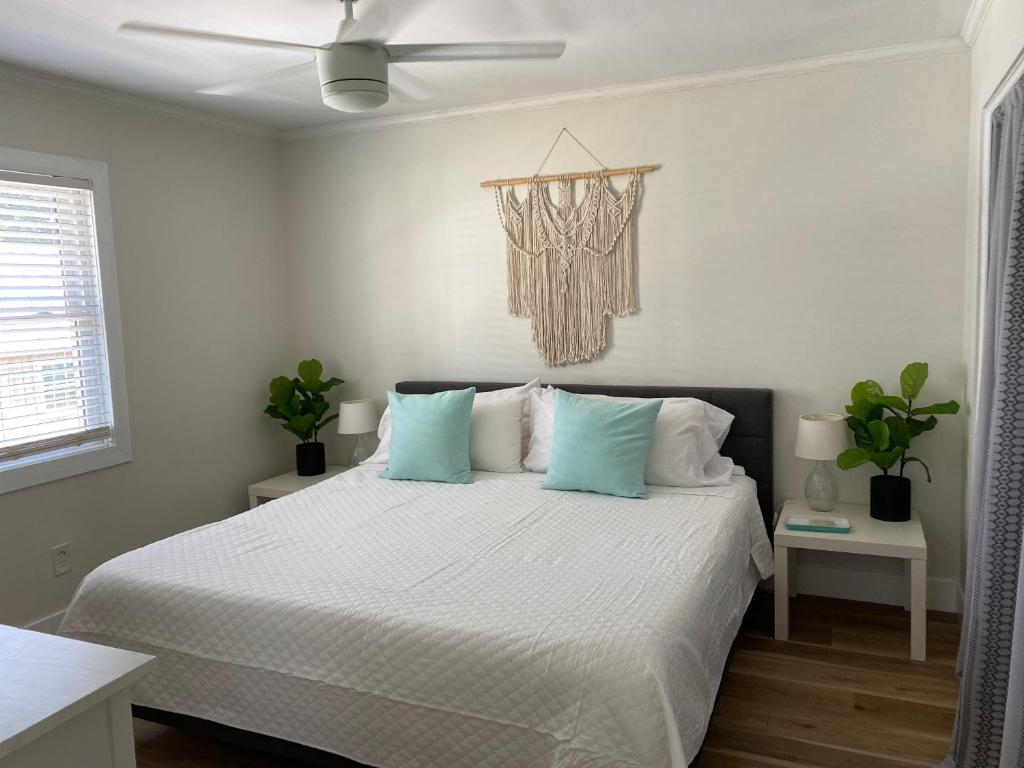 卡罗来纳比奇Island Time的白色卧室配有蓝色枕头的床