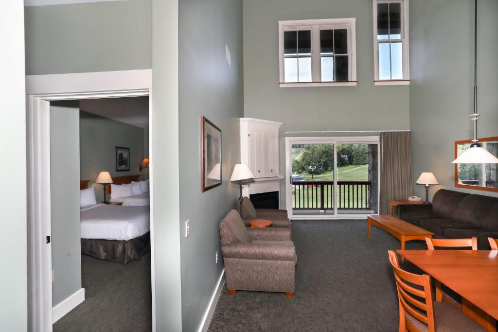 拉德洛Jackson Gore Village on Okemo Mountain的酒店客房设有床和客厅。