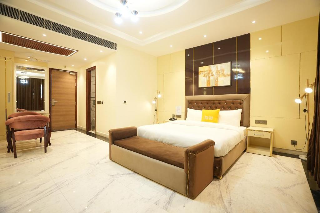 大诺伊达Lime Tree Hotel and Banquet Greater Noida的一间卧室配有一张大床和一把椅子