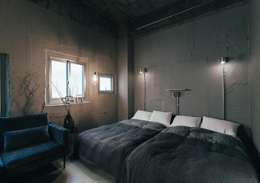 热海Kiten - slow & work stay -的卧室配有床、椅子和窗户。