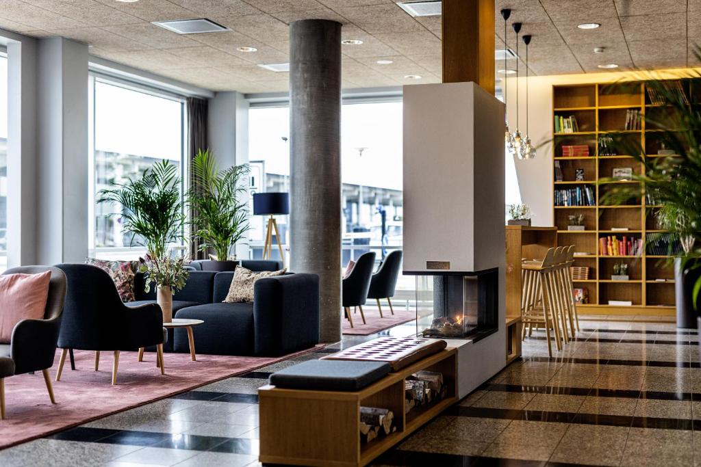 奥尔堡奥尔堡机场酒店的大堂配有沙发、椅子和壁炉