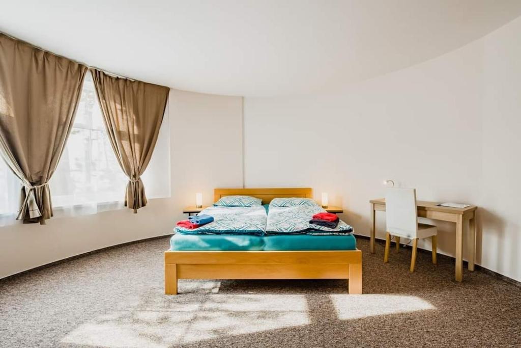 Sezimovo Ústí维加汽车旅馆的一间卧室配有一张床、一张桌子和一张书桌
