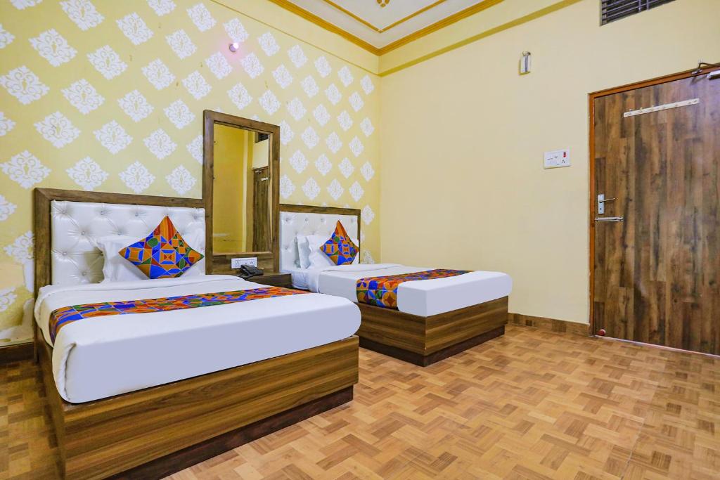 瓦拉纳西FabHotel Shivam Palace的一间卧室,配有两张床