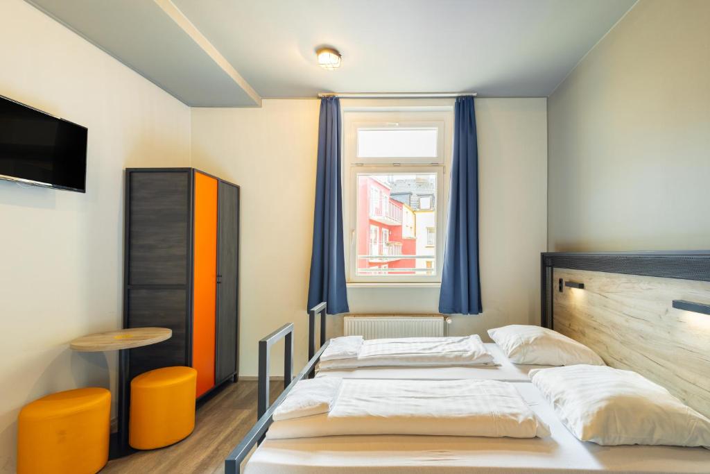 多特蒙德多特蒙德火车总站a＆o酒店的一间卧室设有两张床和窗户。