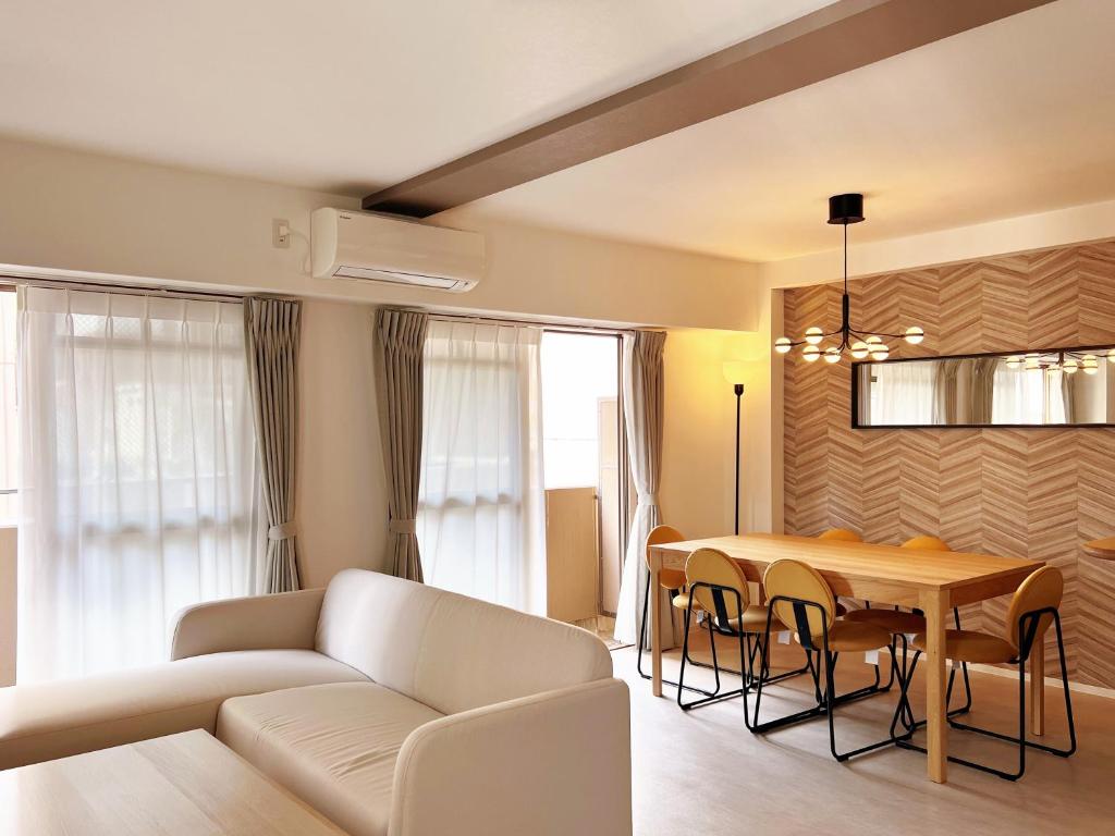 大阪Dio Higashi Shinsaibashi的客厅配有白色的沙发和桌子