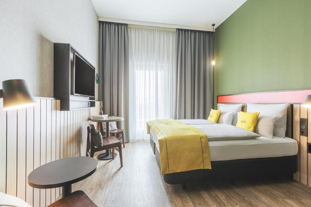 波茨坦acora Potsdam Living the City - Apartments的酒店客房配有一张床铺和一张桌子。