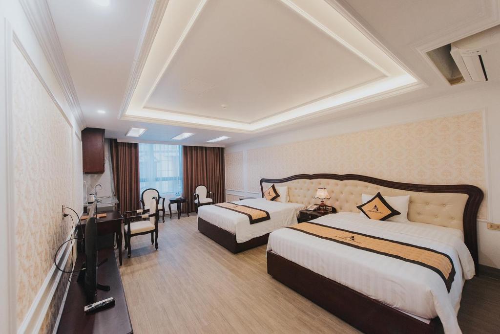 海阳Asean Hotel的酒店客房配有两张床和一张书桌