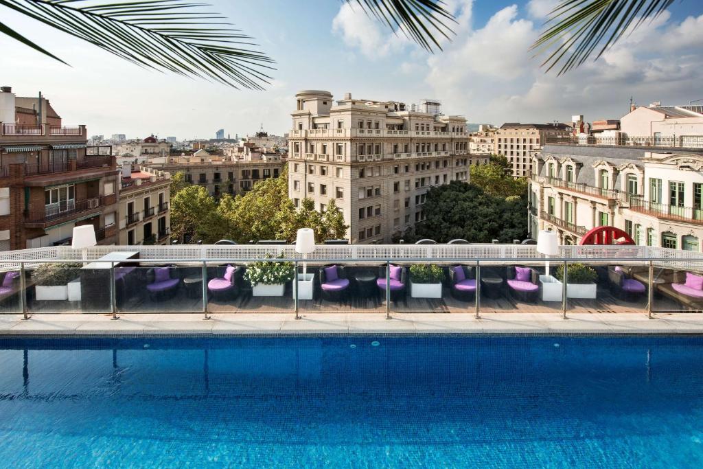 巴塞罗那巴塞罗那博迪姆NH酒店的从带游泳池的建筑屋顶上欣赏美景