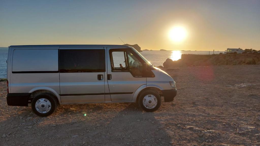 圣塔格鲁迪斯Casa movil的一辆白色的货车停在海滩上,日落时分