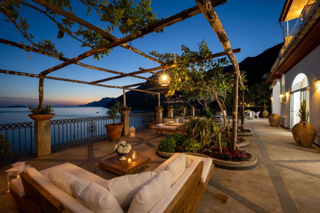 波西塔诺YourHome - Villa Aldo Marino的带沙发并享有水景的天井
