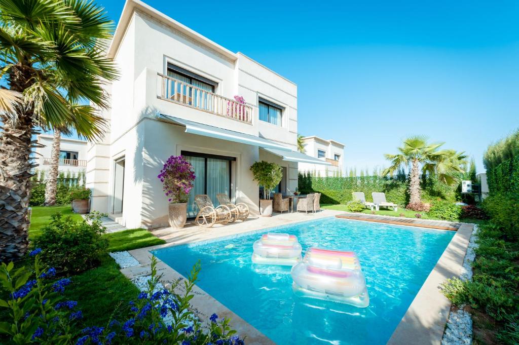 阿加迪尔Villa Palmeraie Golf Agadir的别墅前设有游泳池