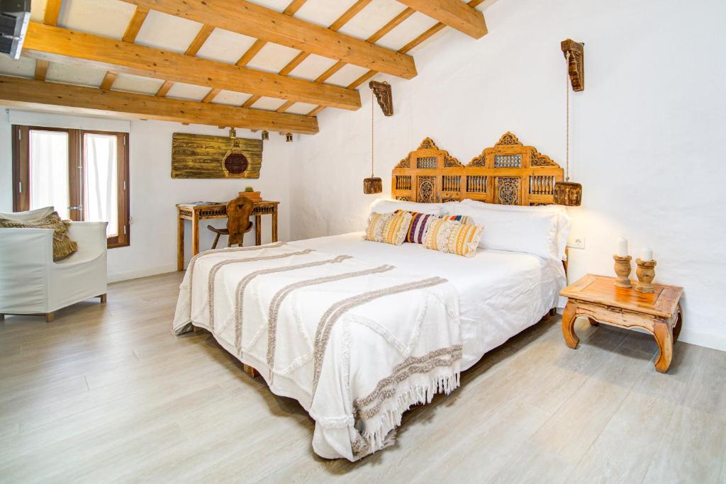 休达德亚Calma Hotel的卧室配有一张白色的大床和一张桌子