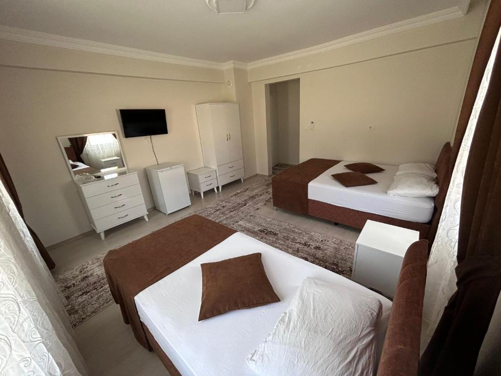 帕莫卡莱Paradise Boutique hotel的酒店客房设有两张床和电视。