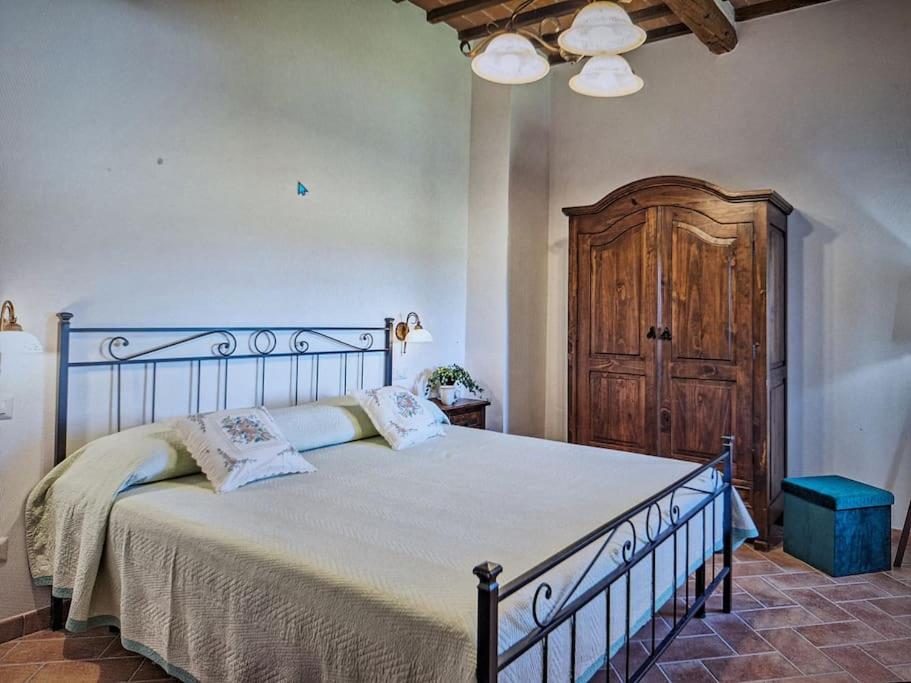蒙特普齐亚诺Dimora del Grillo的一间卧室设有一张大床和一扇木门