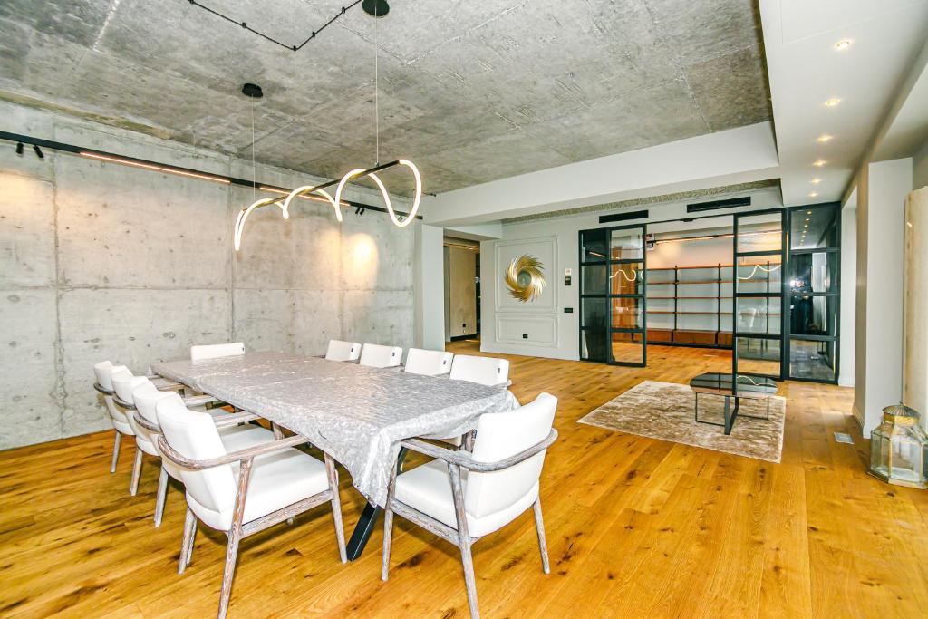 巴库Park Vurğun Residance Loft Designer的一间带桌子和白色椅子的用餐室