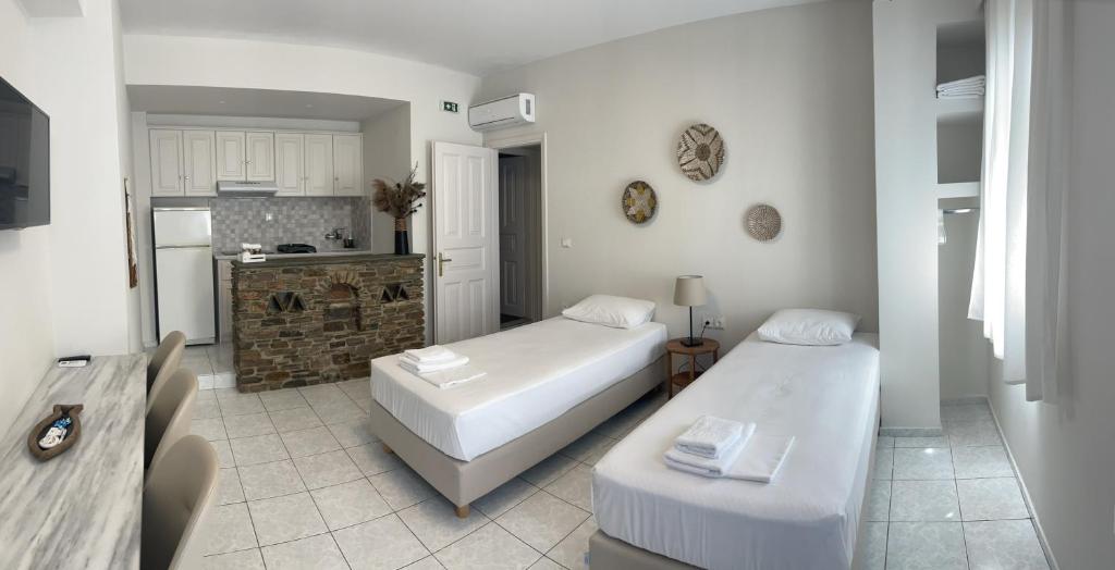提诺斯曼托公寓式酒店的一间带两张床的客厅和一间厨房