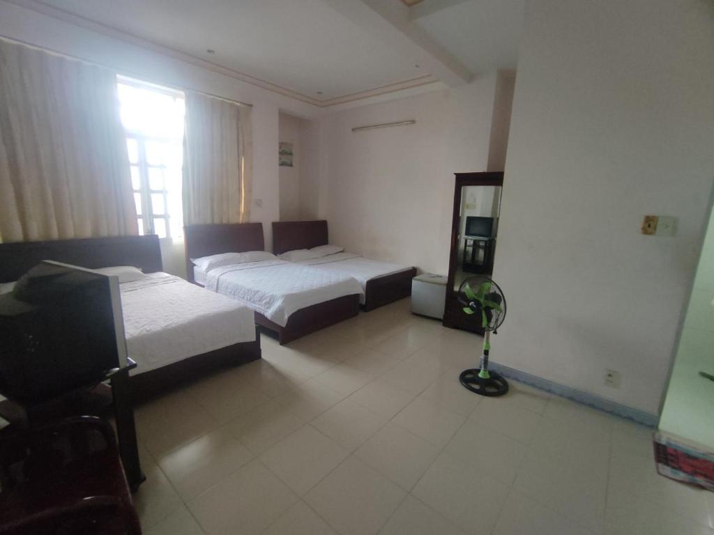 芽庄Khách sạn Phú Phương的酒店客房,设有两张床和镜子