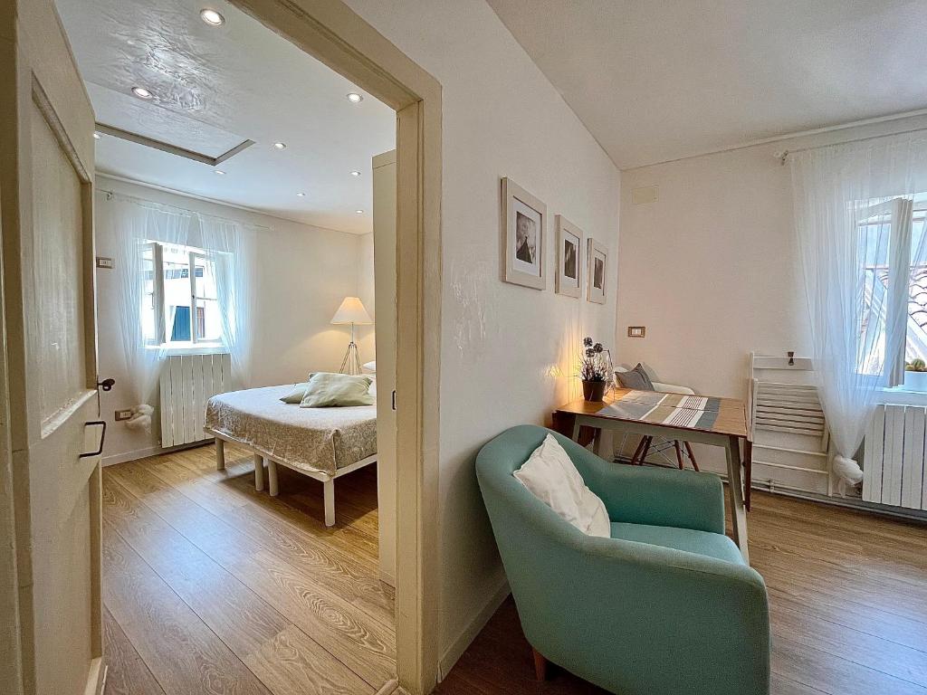 格拉多Casa Calle del Forno的一间带蓝椅的客厅和一间卧室