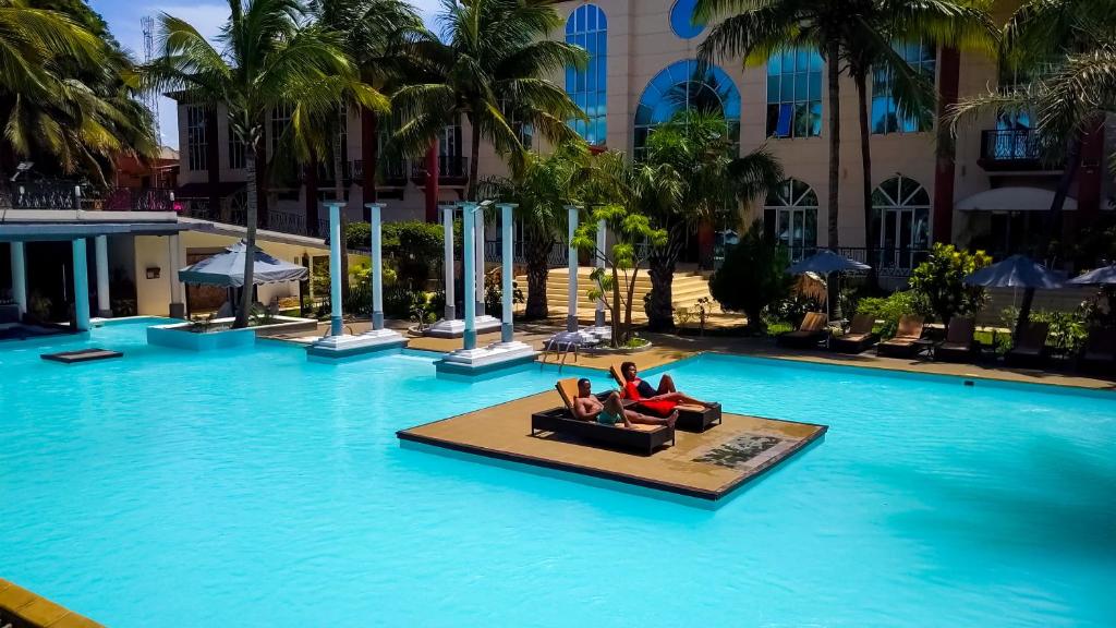 迭戈苏瓦雷斯Le Grand Hôtel Diego的两个人躺在酒店的游泳池里