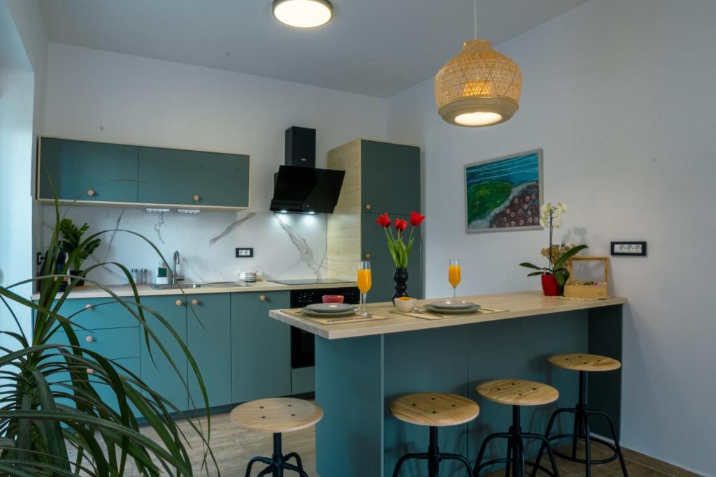 里耶卡Deluxe Apartment and Studio "Nona Fa"的厨房配有蓝色橱柜和酒吧凳子