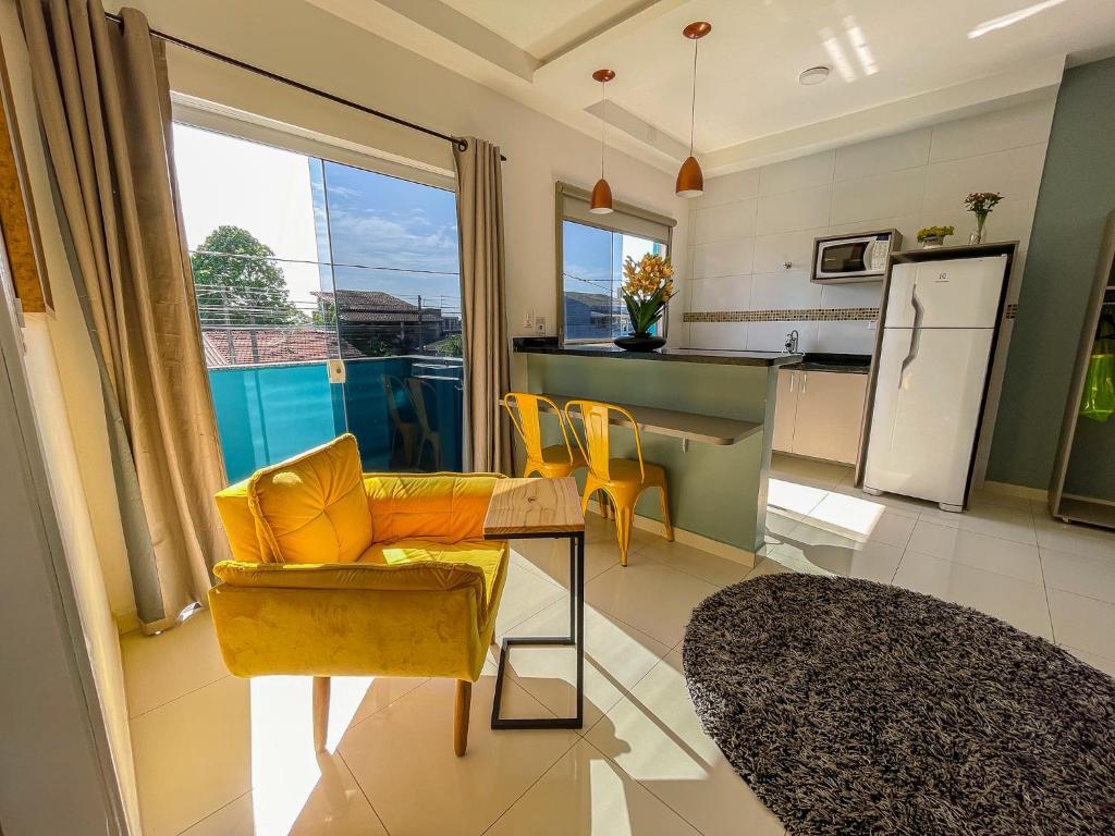 伊塔尼亚恩Mangata Loft - Requinte e Conforto para Lazer ou Trabalho的一间带黄色沙发的客厅和一间厨房