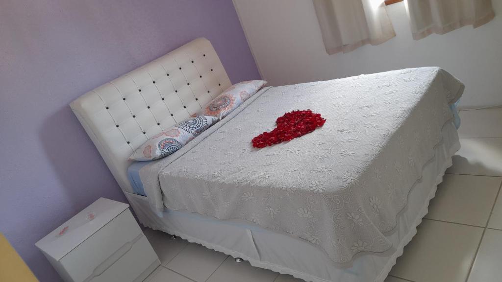 安格拉杜斯雷斯Hospedaria Casa de Maria的一张白色的床,上面有红色的心