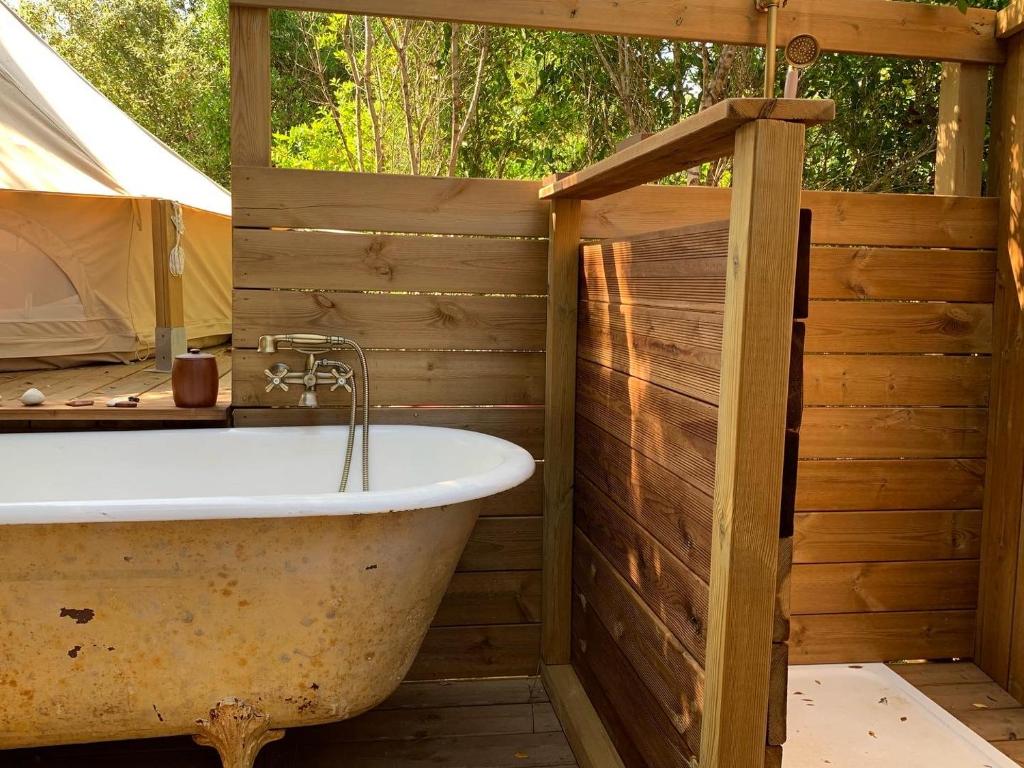 科蒂基亚瓦里Corsica Natura #2的带浴缸的木制浴室,配有帐篷
