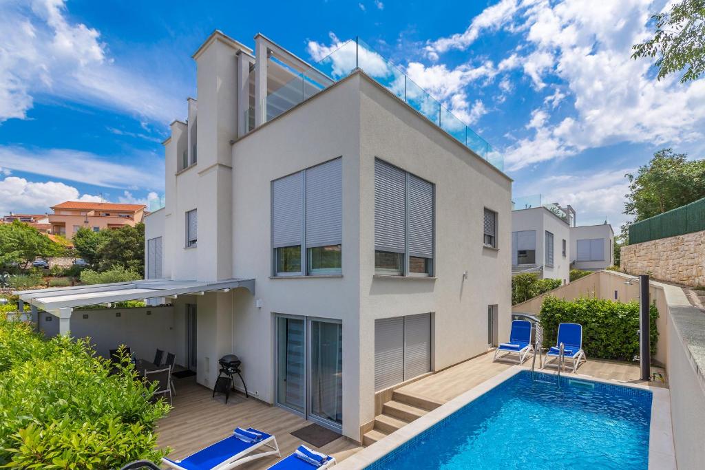 马林斯卡Villa Nika的一座带游泳池和两把蓝色椅子的房子