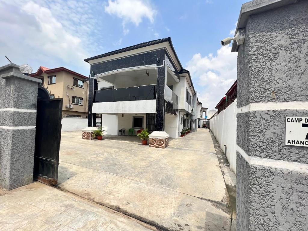 拉各斯CampDavid Luxury Apartments Ajao Estate Airport Road Lagos 0 8 1 4 0 0 1 3 1 2 5的一条空的街道,有一座带车库的建筑