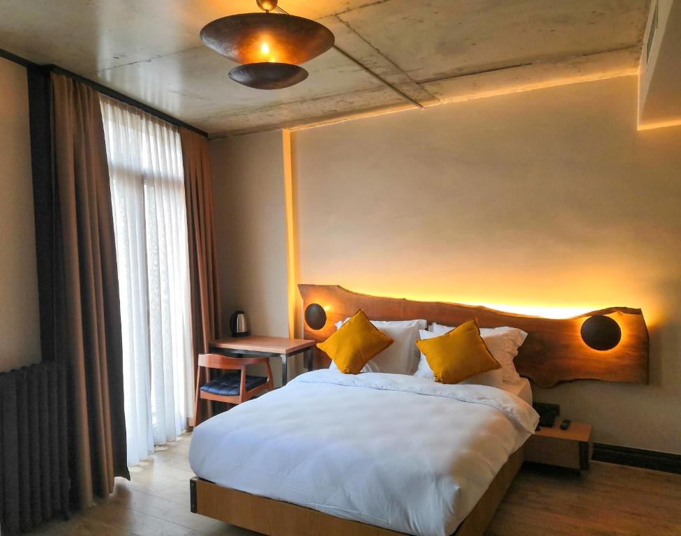 伊斯坦布尔Taksimbul Design Hotel的卧室配有一张带黄色枕头的大型白色床。
