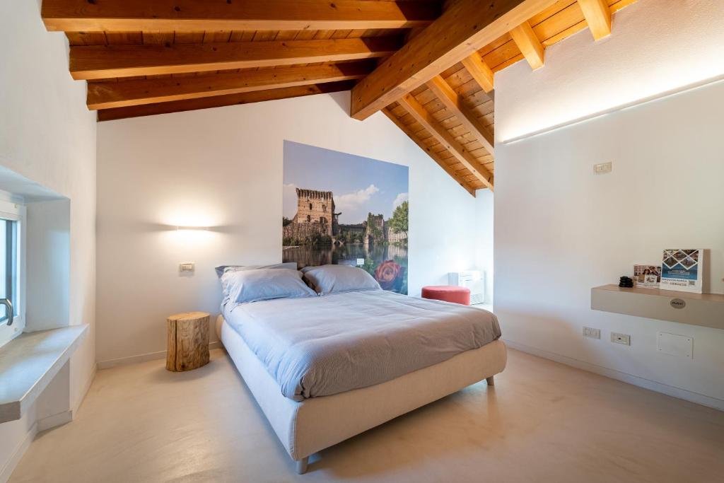 明乔河畔的瓦雷奇奥Una Rosa sul Mincio的一间卧室设有一张带木制天花板的大床